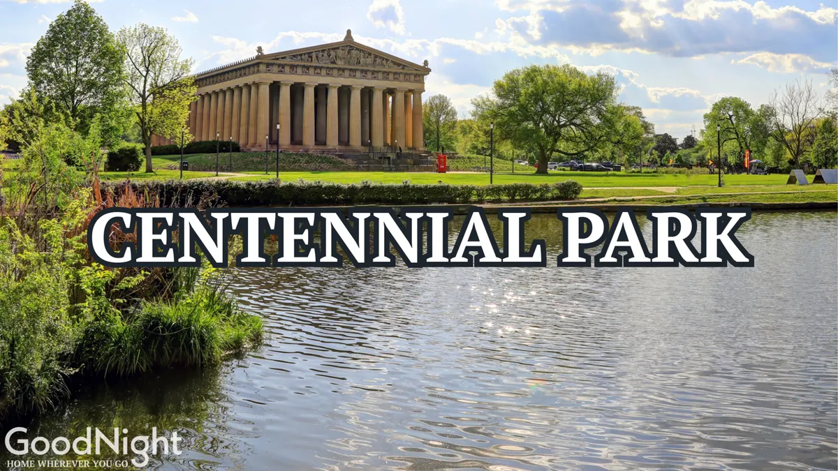 A scenic, sunlit view of Centennial Park featuring the iconic Parthenon replica, serene waters, and lush greenery. Families and visitors can be seen enjoying the walking paths and the open park space, making it an inviting destination for play, picnics, and exploration.